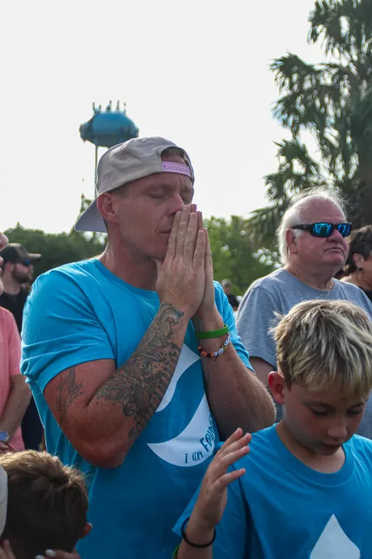 Father praying with son at church event